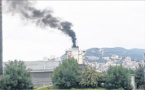 Un bateau sature le ciel de la ville de fumées noires